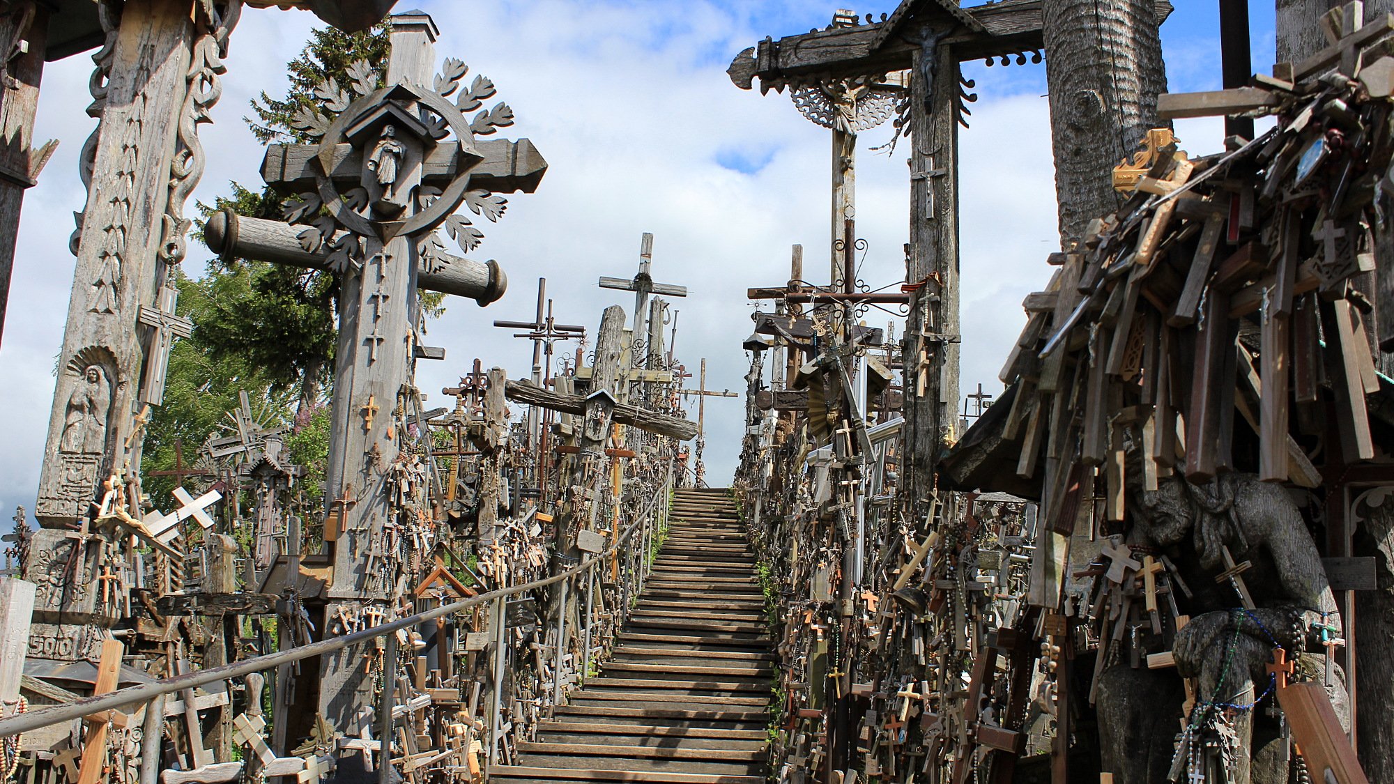 A small wooden path between lines of crosses and crucifixes.