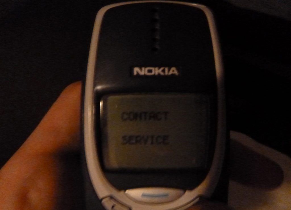 A broken Nokia 3310 with a Contact Service error message.