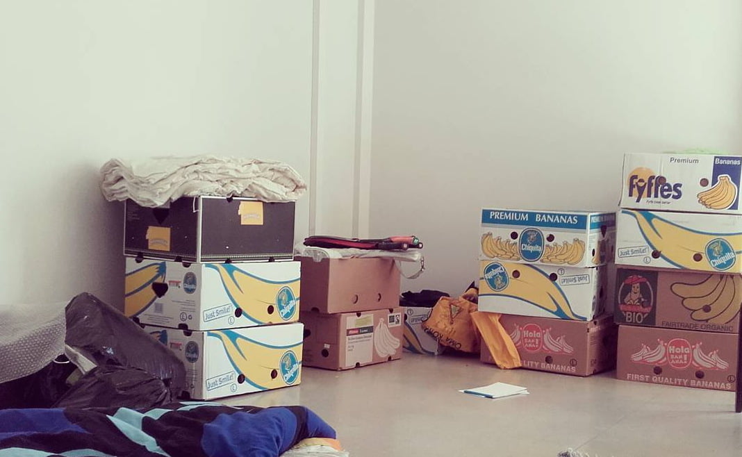 How to save money for traveling? Chiquita boxes used for storage in an empty apartment before moving out.