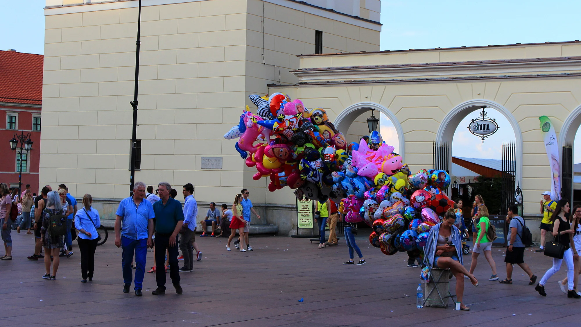 A girl selling balloons that blow in the wind in the Old Town of Warsaw.