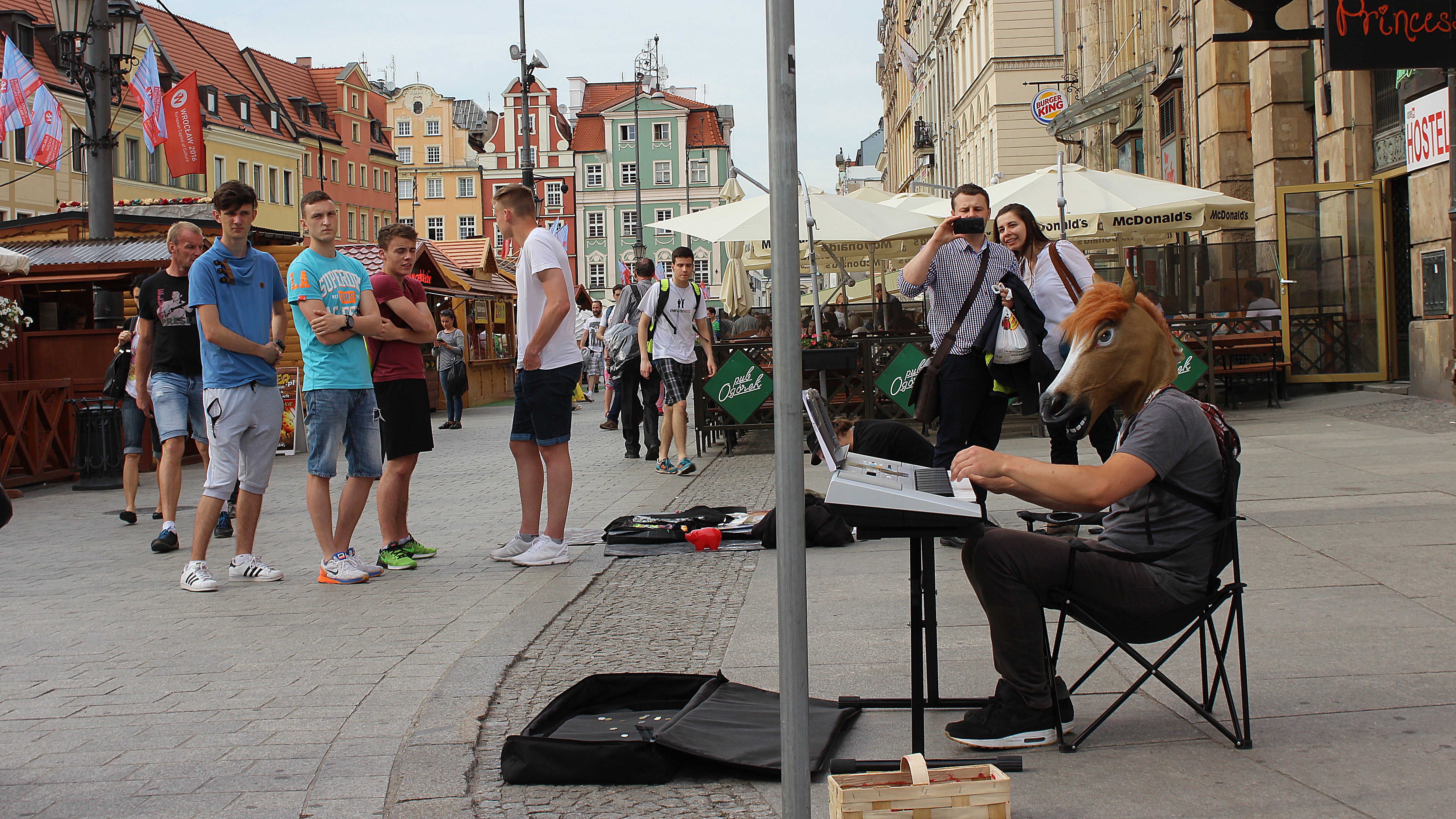 A street musician playing a keyboard with a horse mask in Wrocław, Poland.