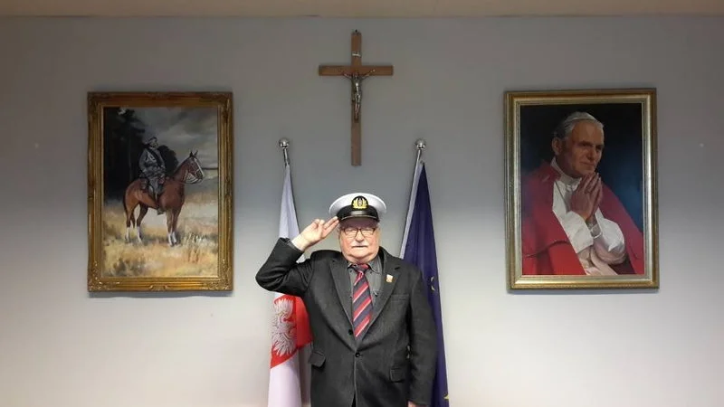 Why Poland is awesome? Lech Wałęsa posing in front of the cross and a painting of Pope John Paul II
