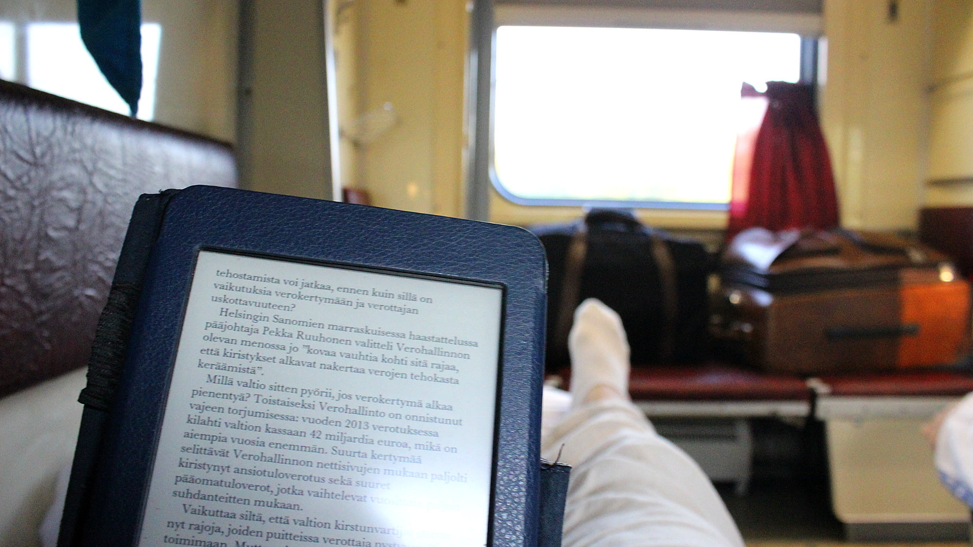 Reading Amazon Kindle Paperwhite when traveling on a sleeper car of a train. A good way to waste time during long train journeys.