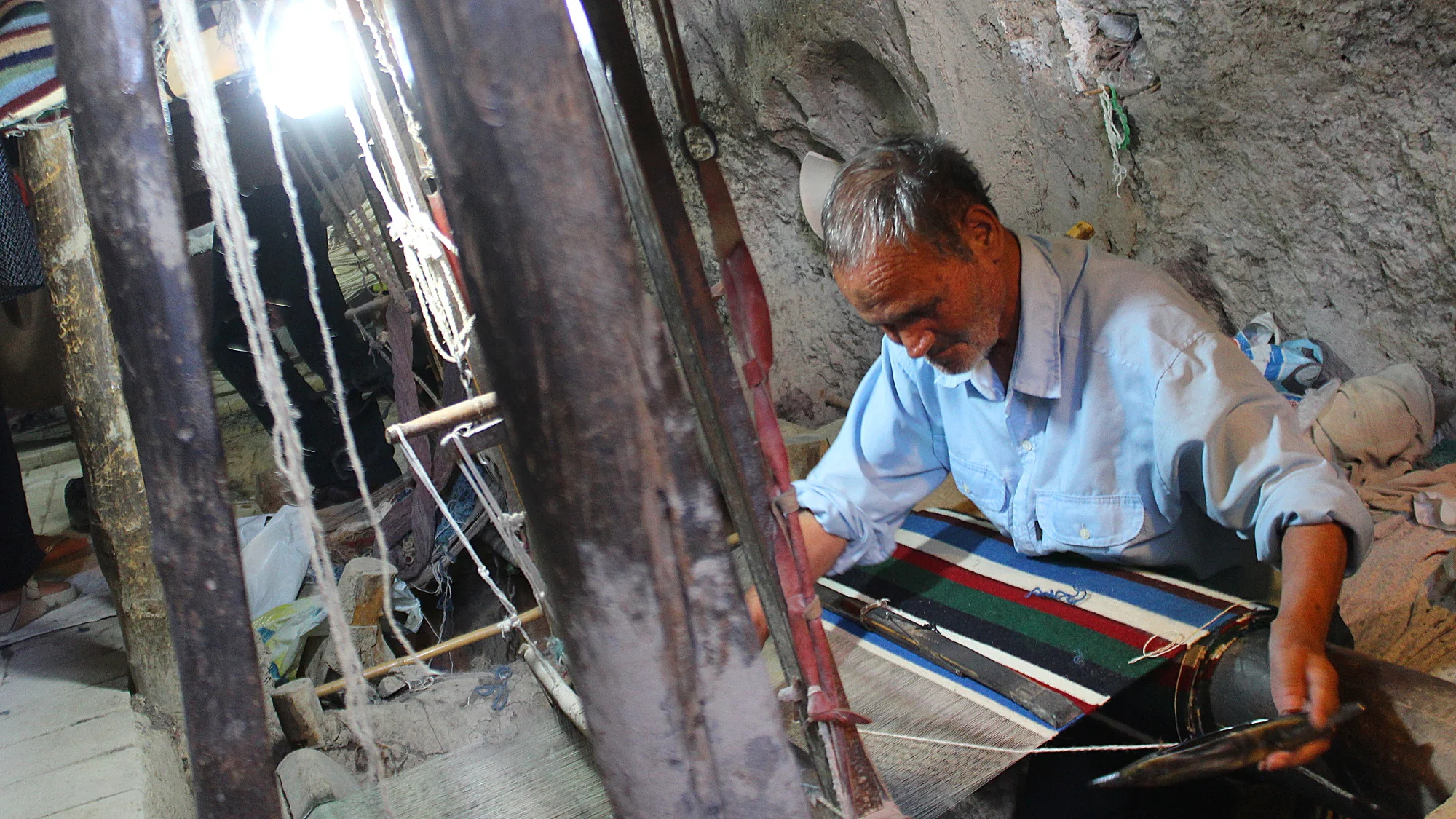 Traditional carpet maker in a cave in Iran.