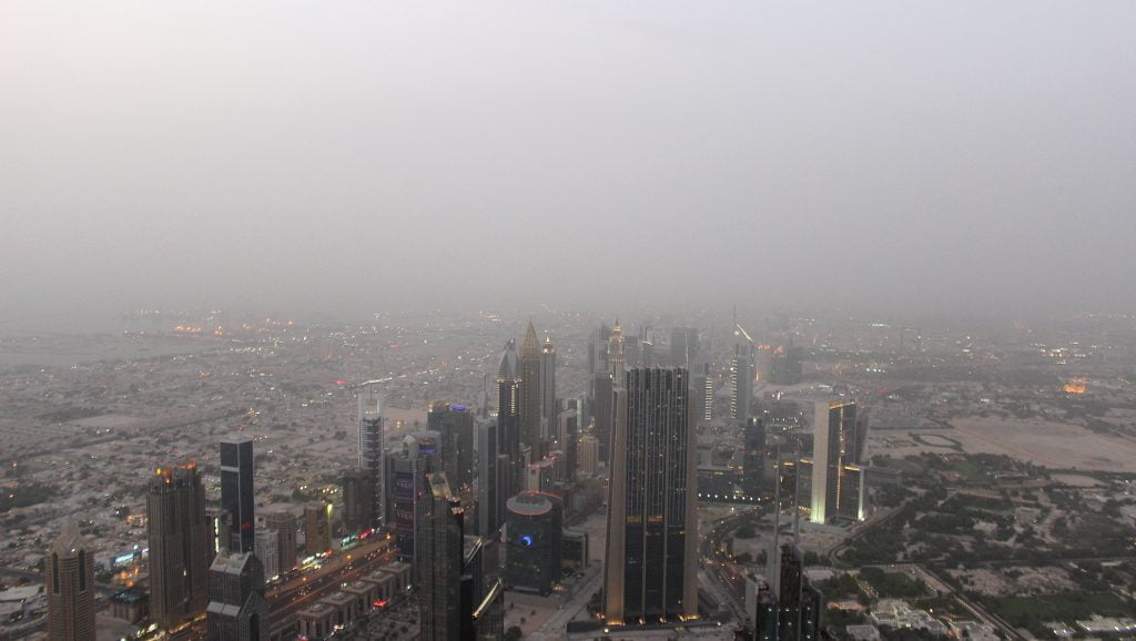 Not the best season to visit United Arab Emirates. View down from Burj Khalifa to other skyscrapers during a misty day.