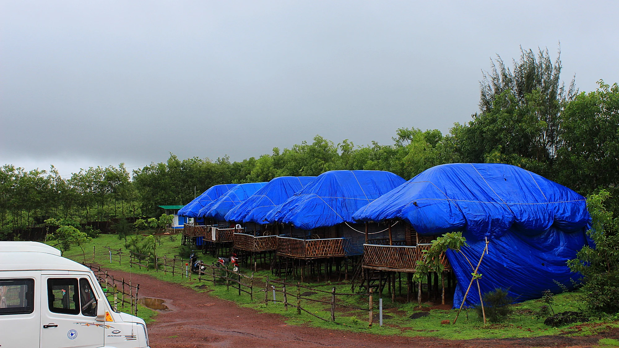 The bungalows of Zostel Gokarna covered with blue tarps for the rain during the Monsoon season.