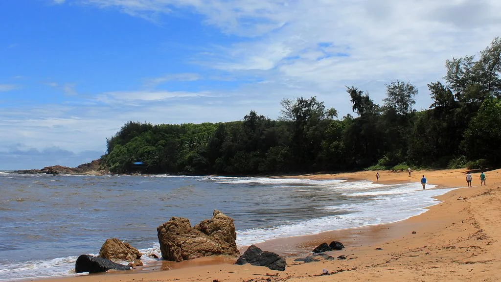 The beautiful Om Beach with a few people walking in the sand in the distance during my stay in Gokarna.