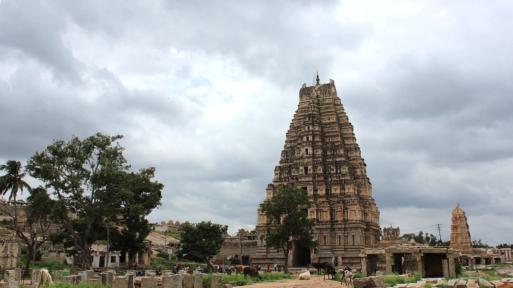 The Virupaksha Temple tower in Hampi with grey clouds in the background. The temple was built when Hampi was the capital of Vijayanagar empire.