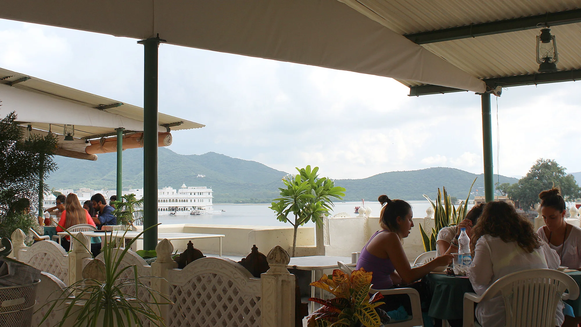 Tourists eating at a rooftop restaurant by the lake Pichola in Udaipur.