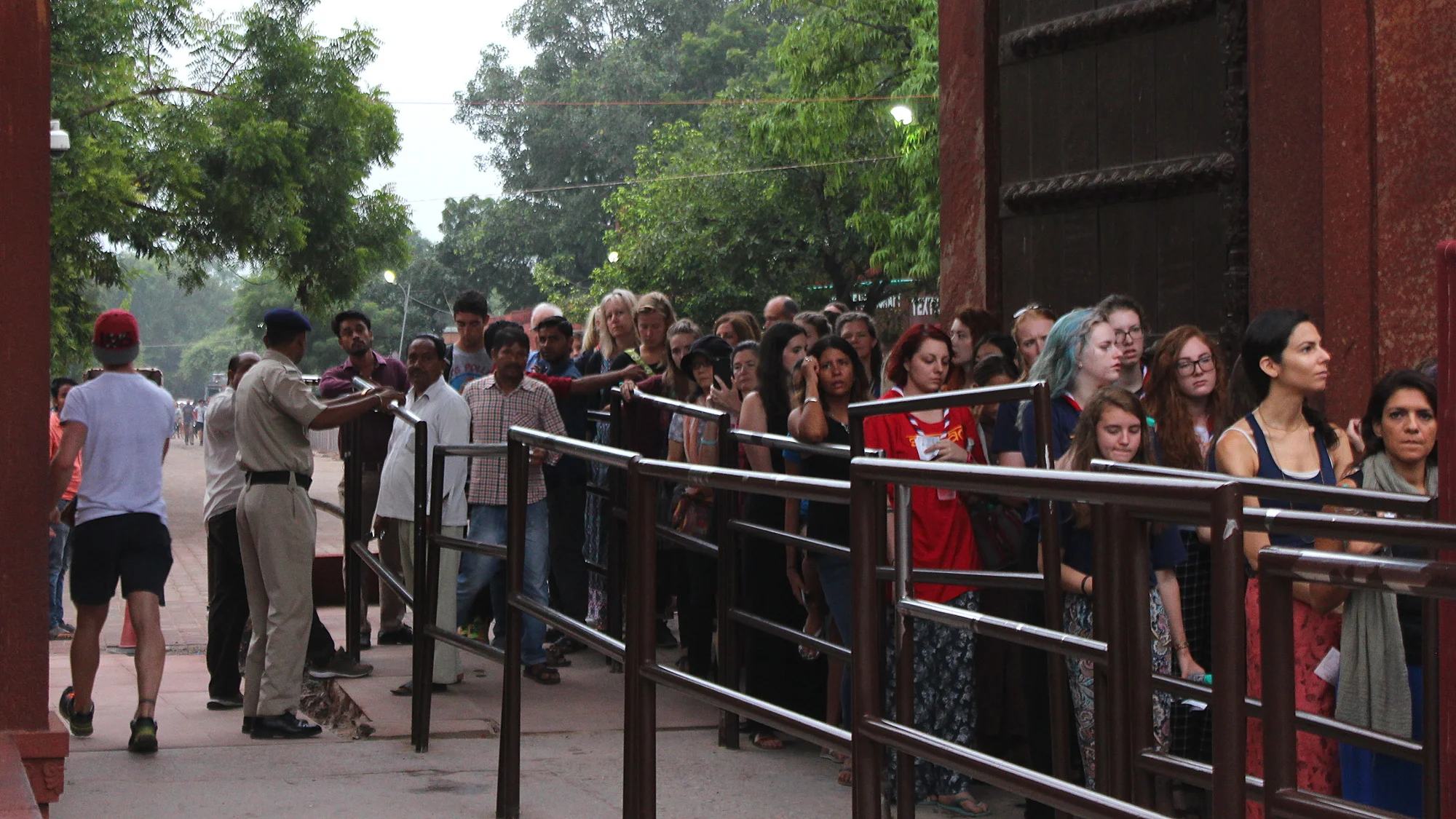 Men and women have separate lines at the entrance to Taj Mahal. The line for men is empty at sunrise, while the line for women continues behind the corner.