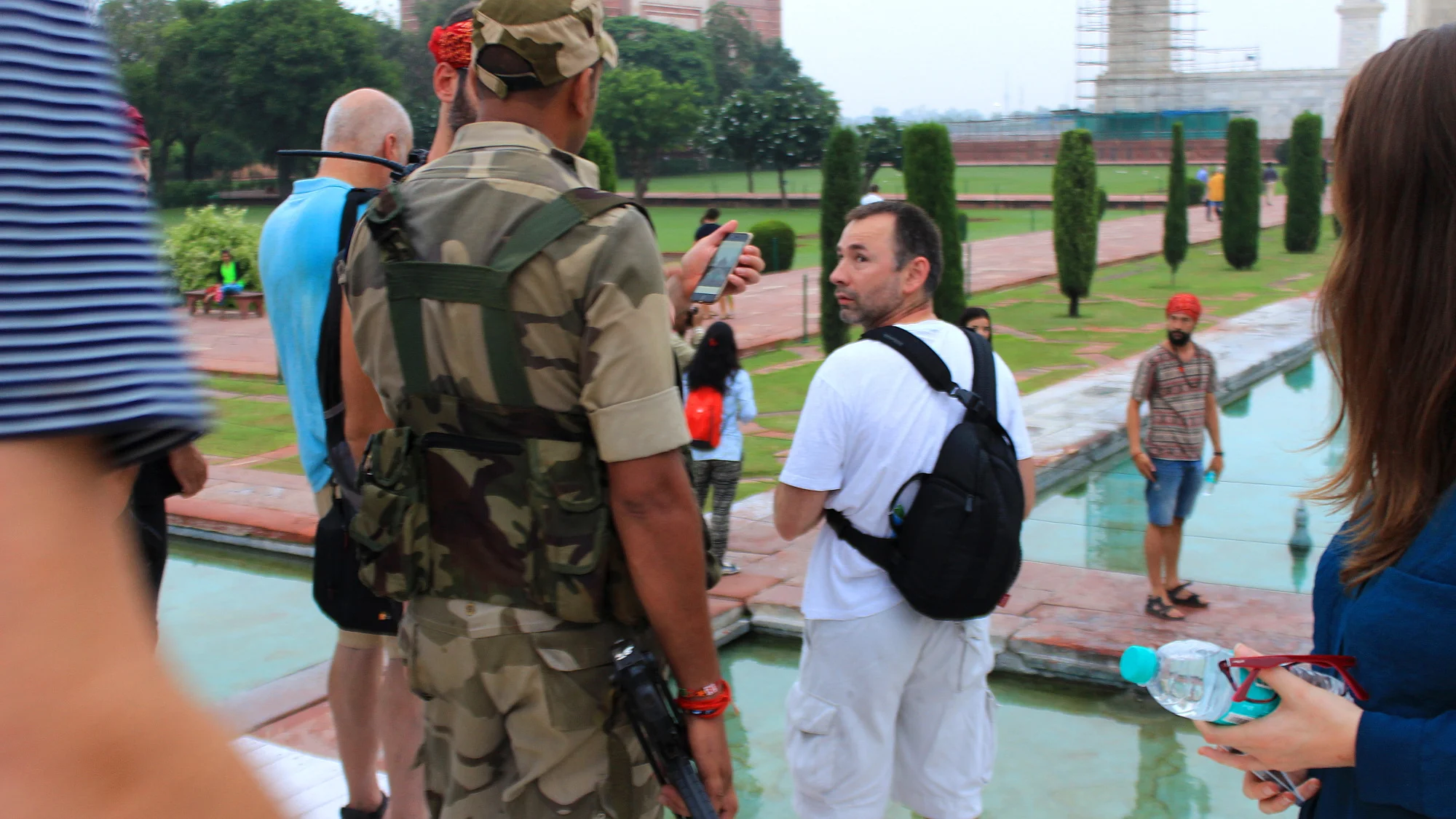 An armed soldier asks a group of tourists to delete their photos where they've posed in the lotus position for the camera.