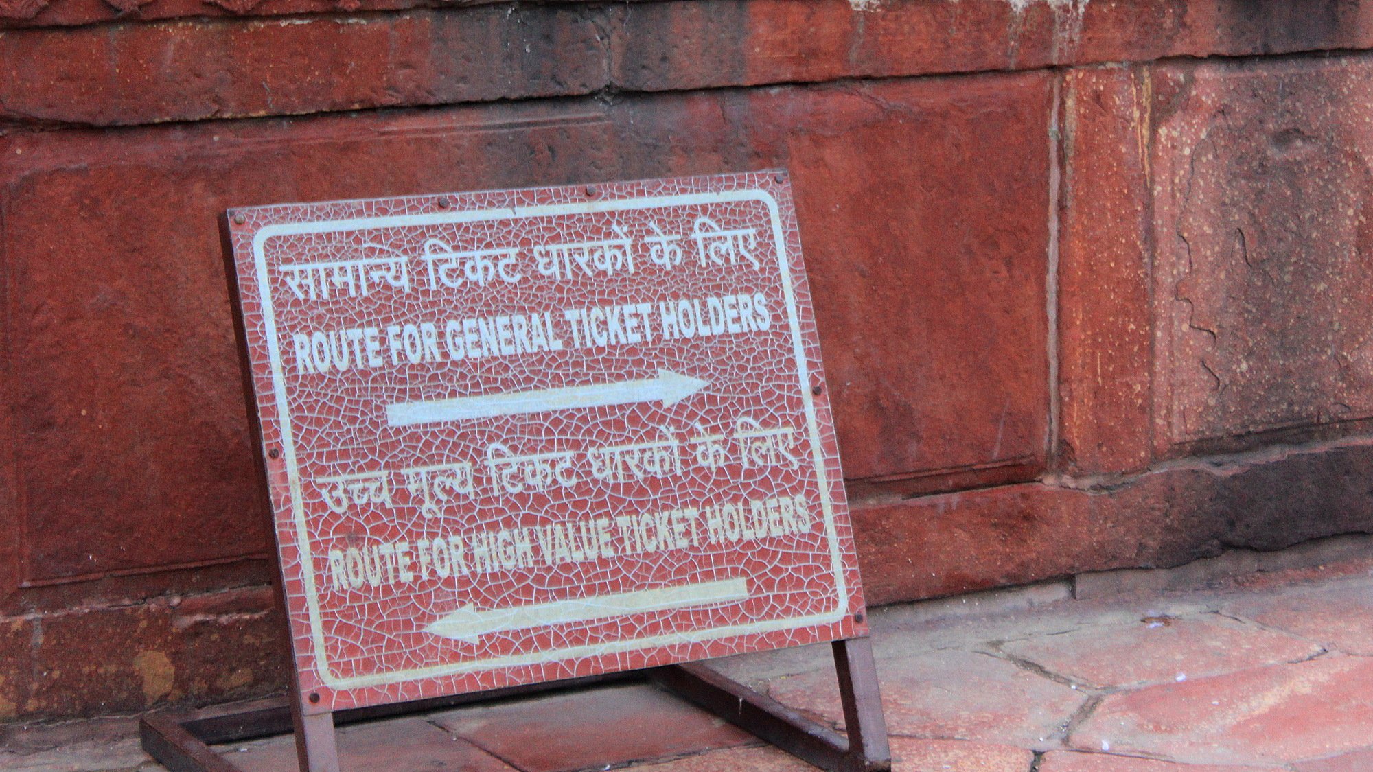 A red signs showing different routes for general ticket holders and high value ticket holders at Taj Mahal, Agra.