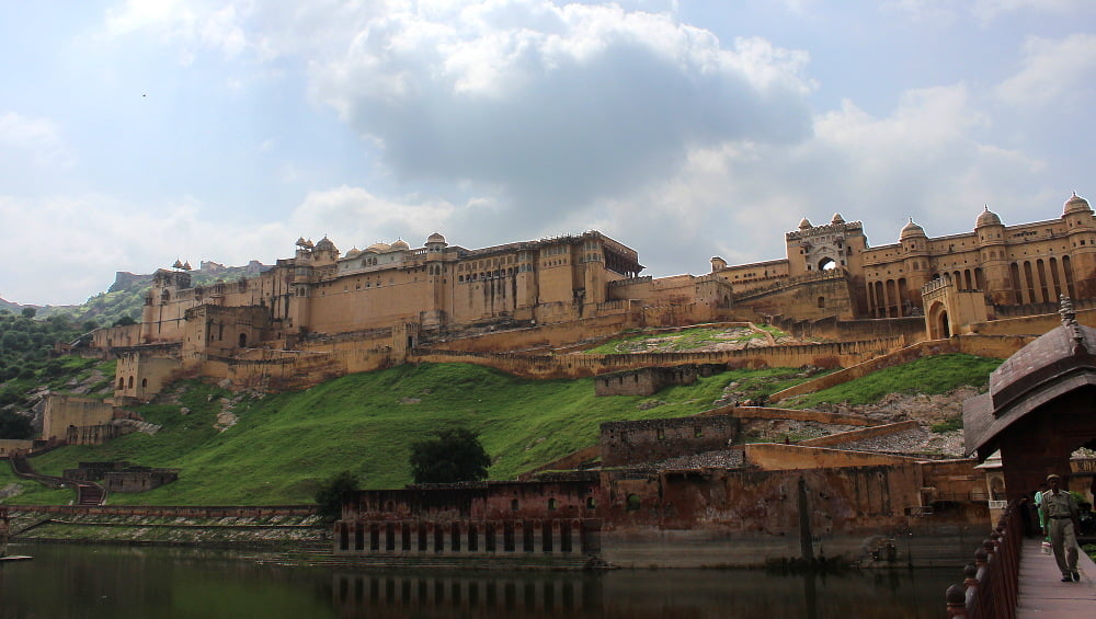 Amer or Amber Fort near Jaipur on a hilltop with a body of water in front.