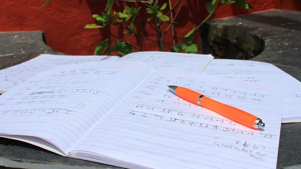 Nepalese letters written on Devanagari script on a school notebook.