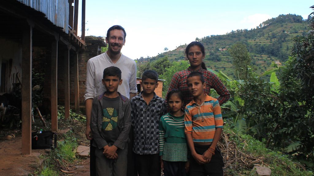 A Western tourist and Nepalese children posing for camera.