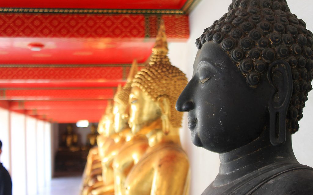 Lifting my travel mod. Gilded Buddha statues from the side in Wat Pho, Bangkok, Thailand.