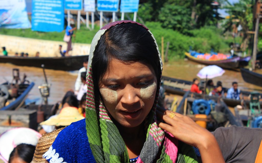 Burma / Myanmar in pictures. A young and pretty Myanmar girl with thanaka face paint on her cheeks by the Inle Lake. Myanmar pictures.