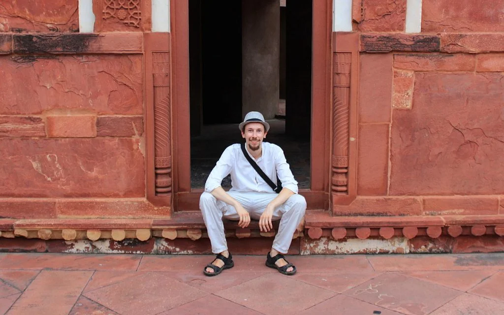 Arimo Koo sitting on steps of Agra Fort, India.