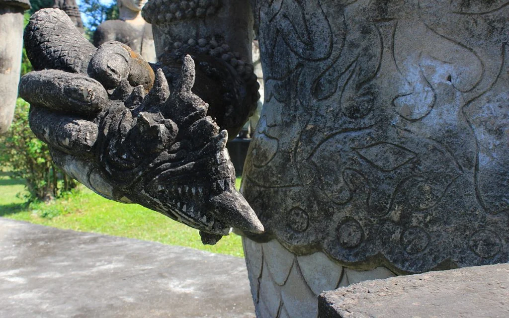 A monster pencil with teeth and tongue in Buddha Park, Laos.