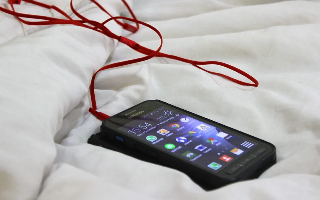 Samsung Galaxy XCover 3 with earplugs attached.