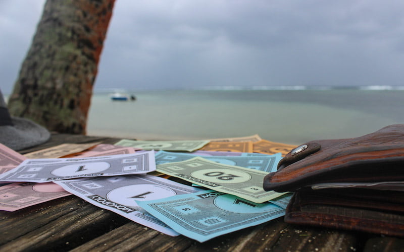 Monopoly money on a beach in Fiji. One Year Travel Budget for a RTW trip.